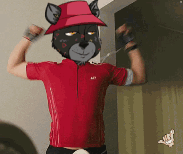 a man wearing a red shirt with a cat face on it flexes his muscles