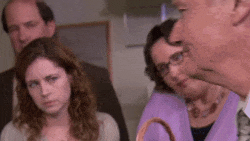 a group of people are standing around a table in a room .