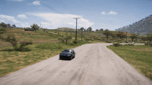 a car is driving down a dirt road in a game