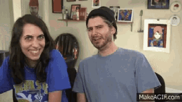 a man and a woman are sitting next to each other smiling .