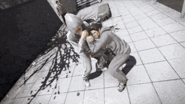 a man in a hoodie is wrestling another man on a tile floor