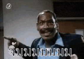 a man in a suit is pointing at something in a room with a foreign language .