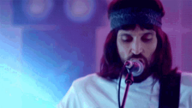 a man with a beard is singing into a microphone