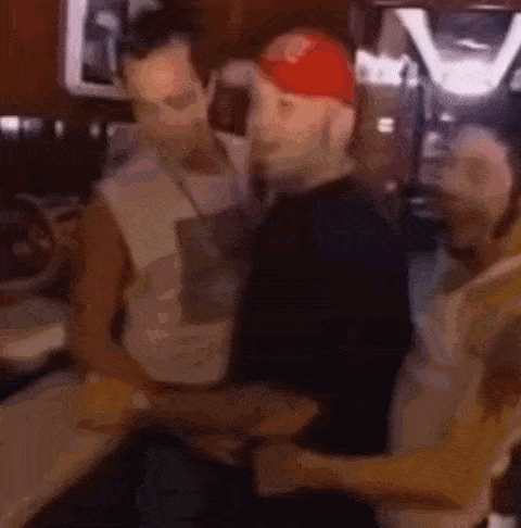 a blurry picture of three men standing next to each other in a kitchen .