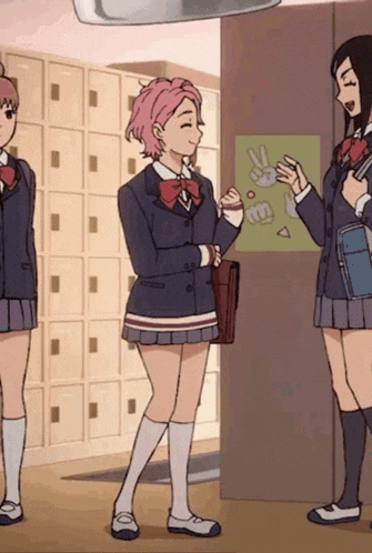 three girls in school uniforms are standing in a hallway talking to each other