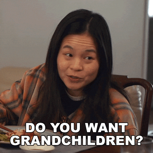 a woman sitting at a table with a plate of food and says do you want grandchildren