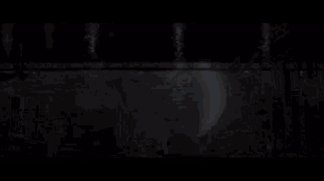 a person standing on a bridge over a body of water at night