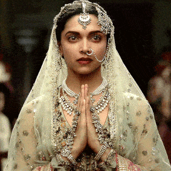 a woman wearing a veil and a nose ring is praying