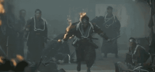 a man in a samurai costume is standing in front of a group of people holding swords .