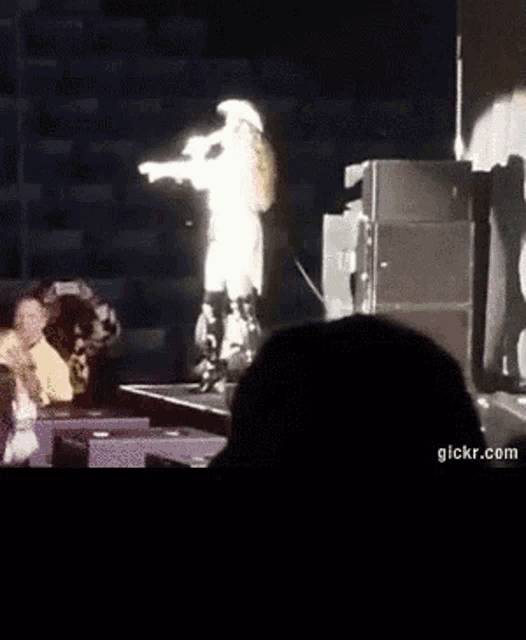 a person is standing on a stage with a microphone in their hand .