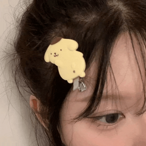 a close up of a person 's face with a hair clip in their hair .