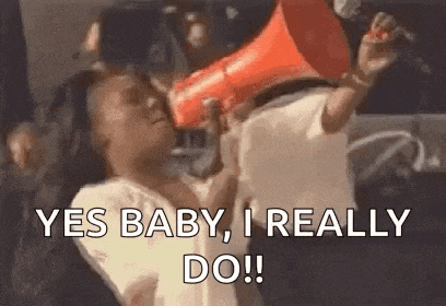 a woman is holding a megaphone in her hand and saying yes baby , i really do .