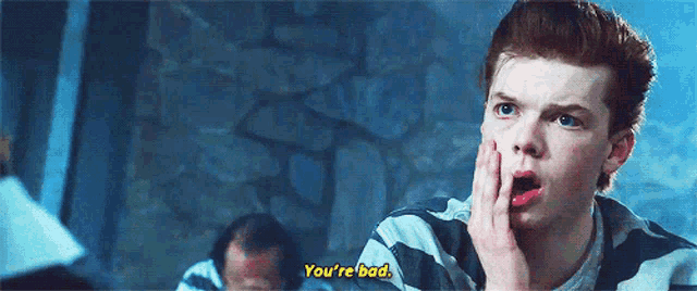 a young man in a striped shirt is saying you 're bad .