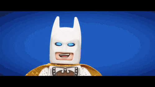 a lego batman figure is smiling and wearing a gold cape