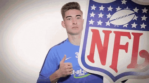 a man in a blue shirt is holding a nfl logo