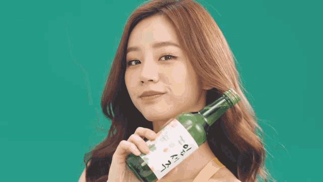 a woman holds a bottle of alcohol with chinese writing on the label