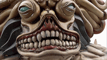 a close up of a statue of a monster with a large mouth
