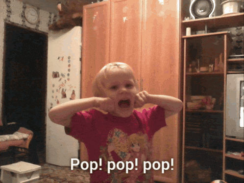 a little girl in a pink shirt is making a funny face and says pop pop pop