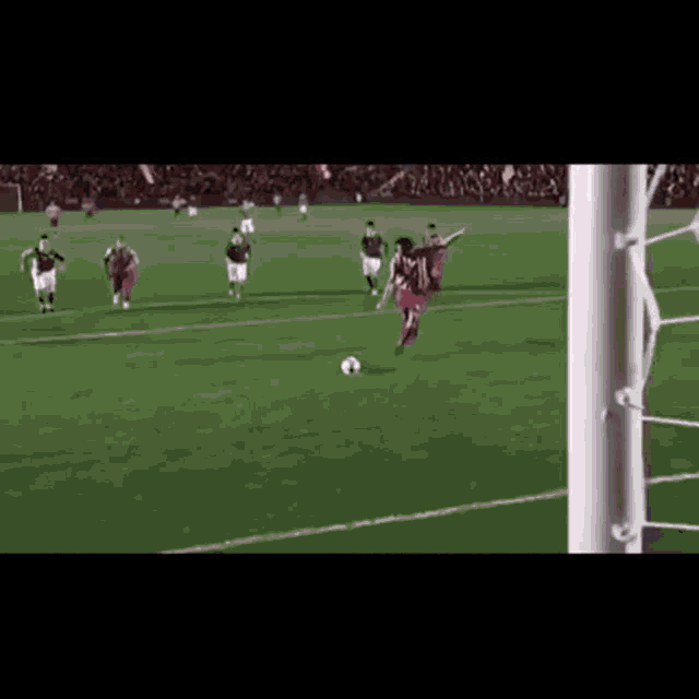 a group of soccer players are playing a game on a field and one of them is jumping in the air to kick the ball .