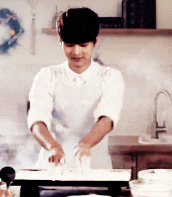 a man in a white apron is preparing food