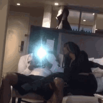 a man and a woman are sitting on a couch in a room taking a picture of themselves .