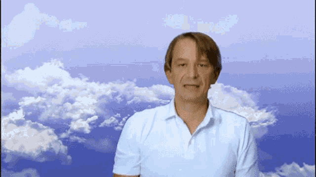 a man in a white shirt is standing in front of a blue sky with clouds
