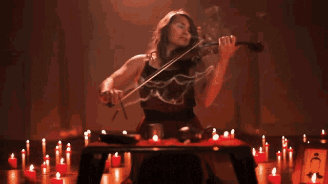 a woman playing a violin in a dark room