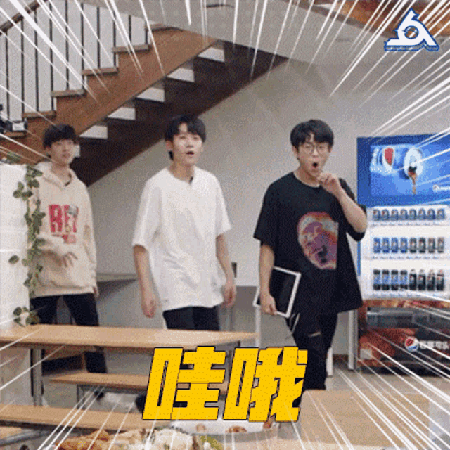 a group of young men are standing around a table with a pepsi machine in the background