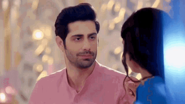 a man and a woman are looking at each other .