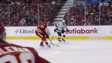 a hockey game is being played in front of a litco advertisement
