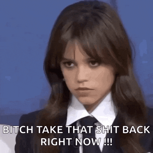 a woman in a suit and tie is making a funny face and saying `` bitch take that shit back right now '' .