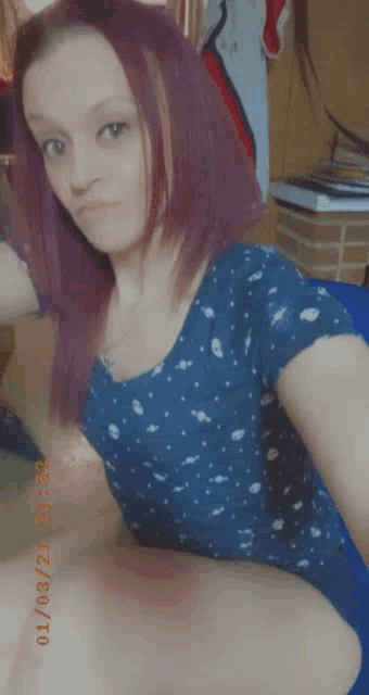 a woman with red hair is taking a selfie with a blue shirt on .