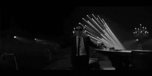 a black and white photo of a man holding a gun with the words lights out assholes written below him