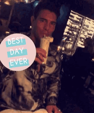 a man drinking a milkshake with a sticker that says best day ever