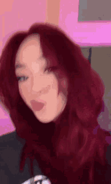 a close up of a woman with red hair making a funny face .