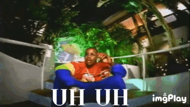 a man is sitting on a couch with the words uh uh on the bottom
