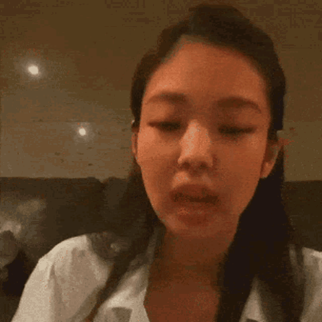 a close up of a woman 's face with a white shirt on .