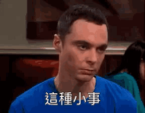 a man in a blue shirt is making a funny face with chinese writing on his face .