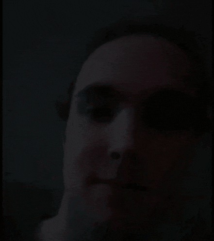 a close up of a man 's face in a dark room .