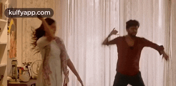 a man and a woman are dancing together in a living room .