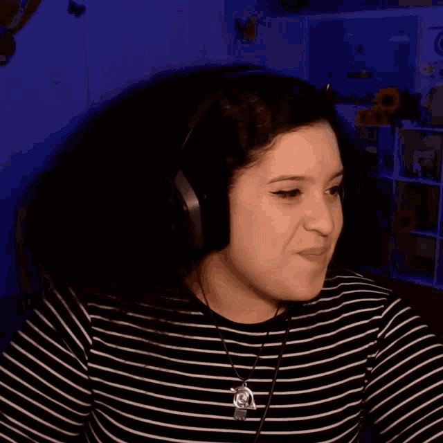 a woman wearing headphones looks at the camera