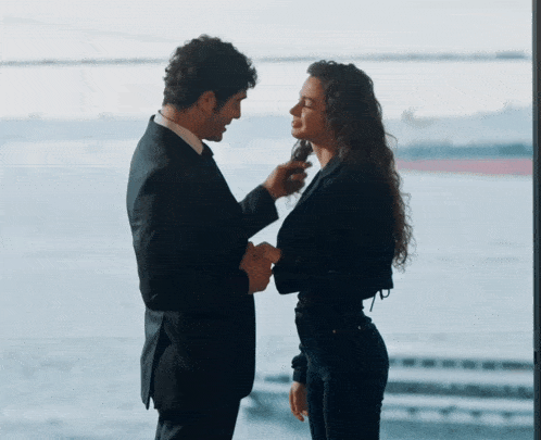a man and a woman are standing next to each other and looking at each other