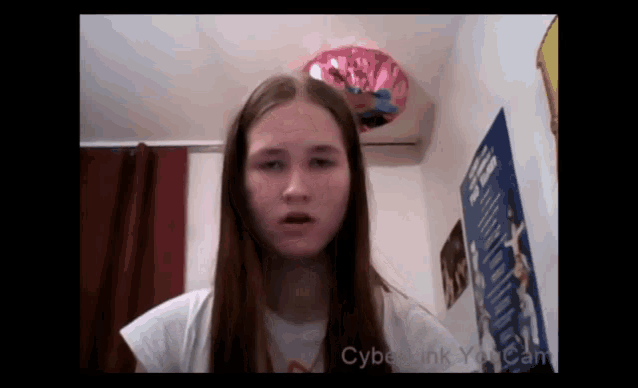 a girl in a room with a poster on the wall that says cybe