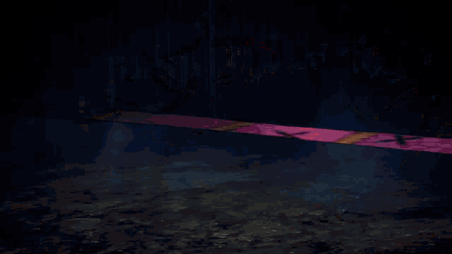 a man and a woman are fighting with swords in a dark room surrounded by fire .