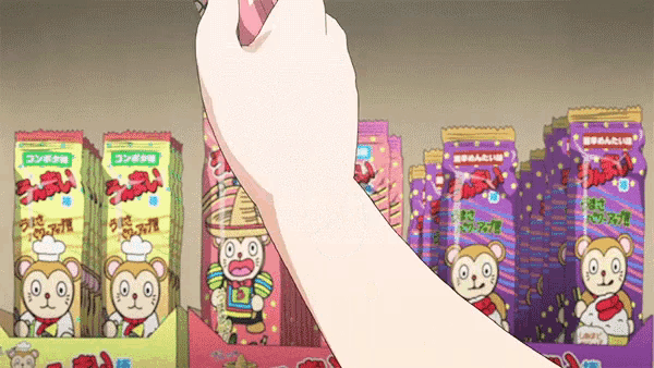 a person is holding a candy bar in front of a display of candy .