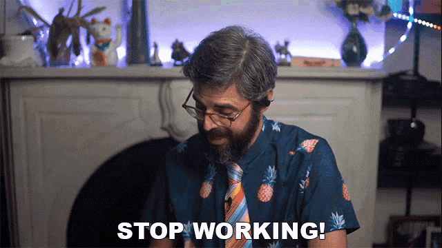 a man with glasses and a pineapple shirt says " stop working "