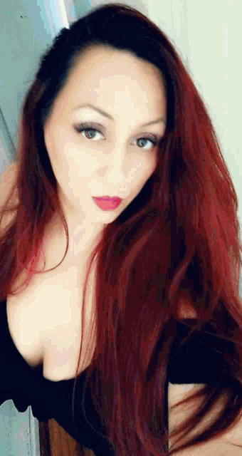 a woman with red hair is wearing a black dress