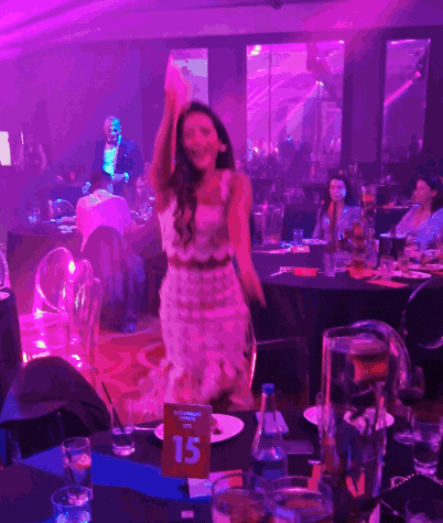 a woman in a white dress stands in front of a table with a sign that says 15