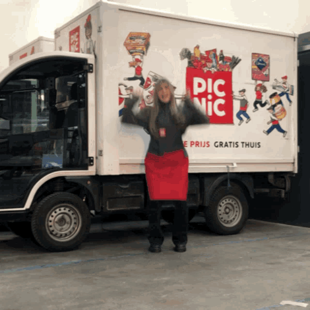 a woman is standing in front of a white truck that says pic nic