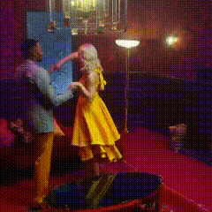 a man and a woman are dancing in a room